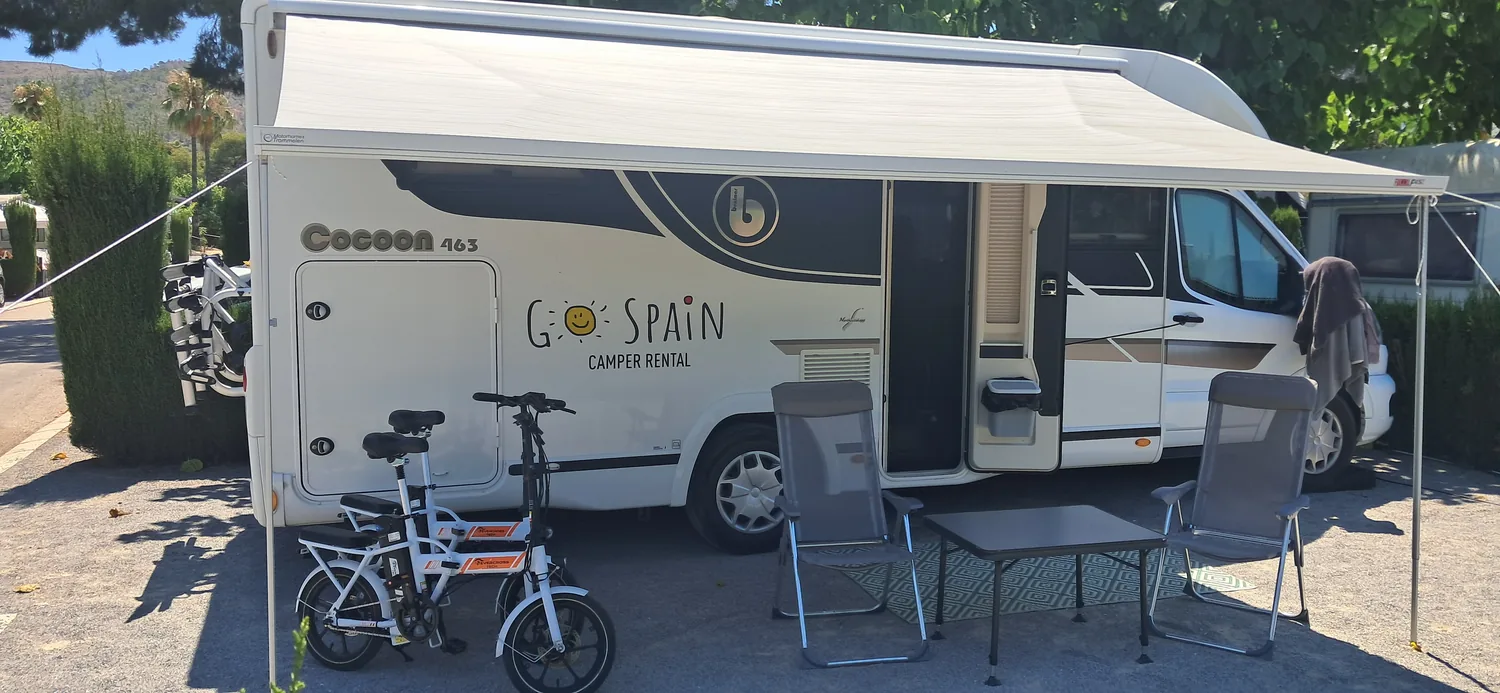 Camper Benidorm with the awning out, table and bikes