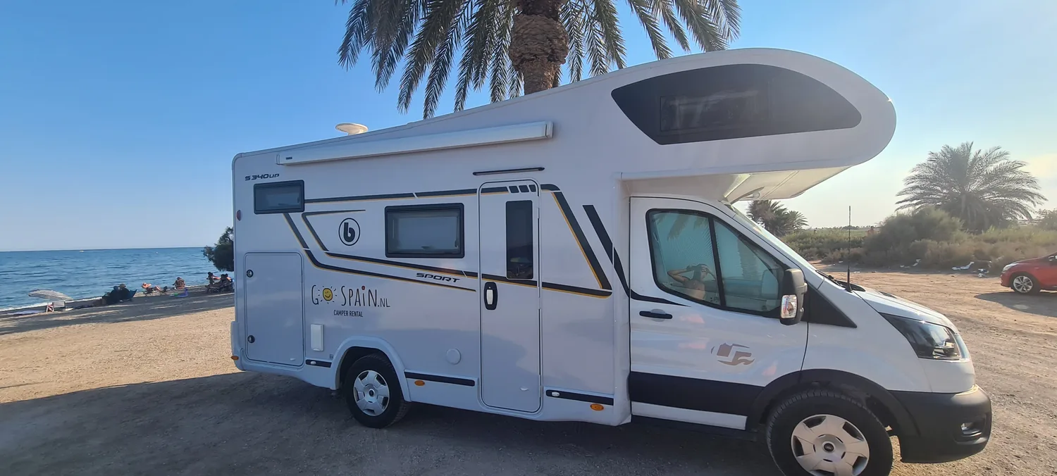 Camper Denia among the palm trees by the sea